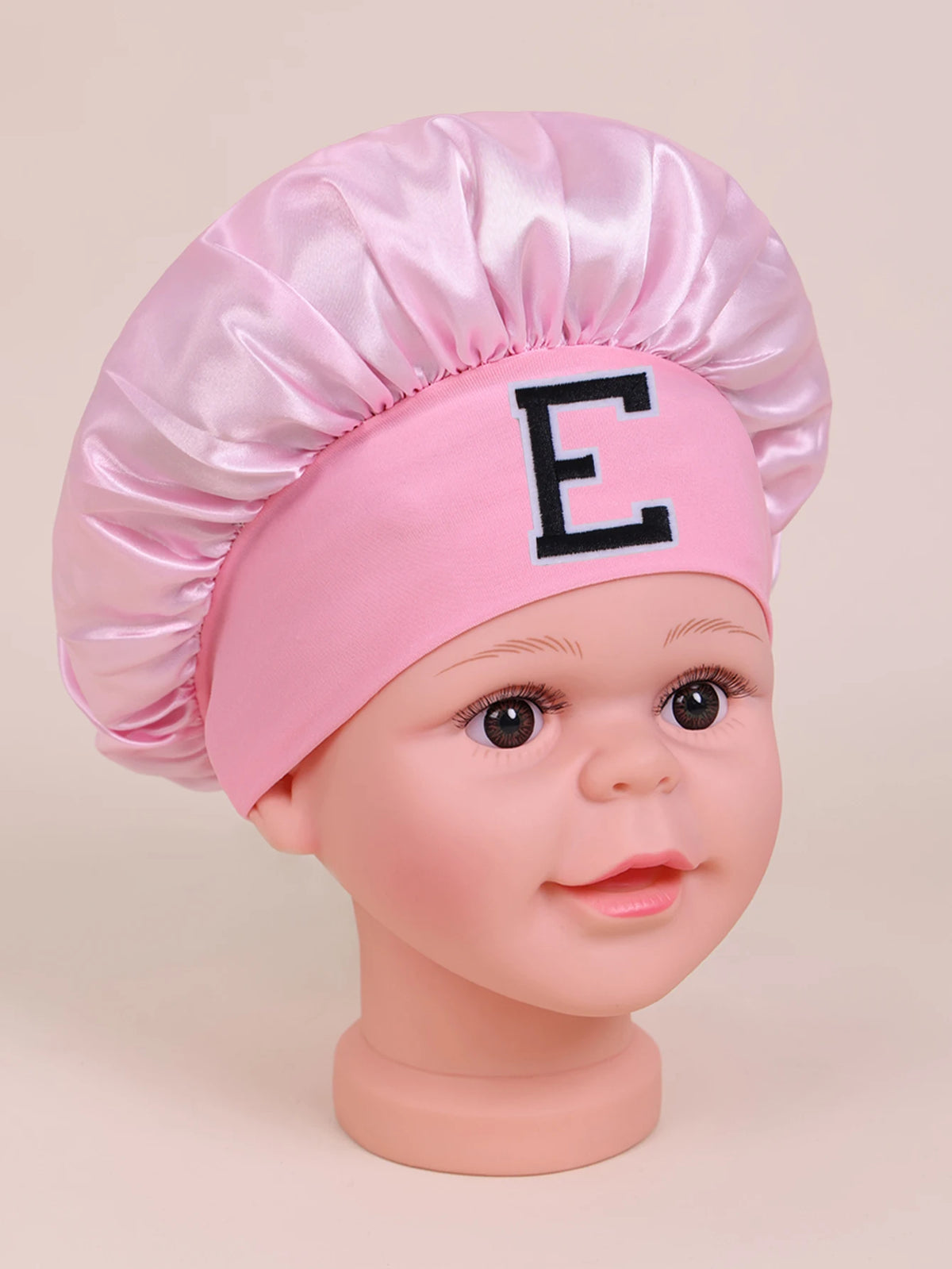 Pink A-Z letter sleep cap for kids with a black letter E