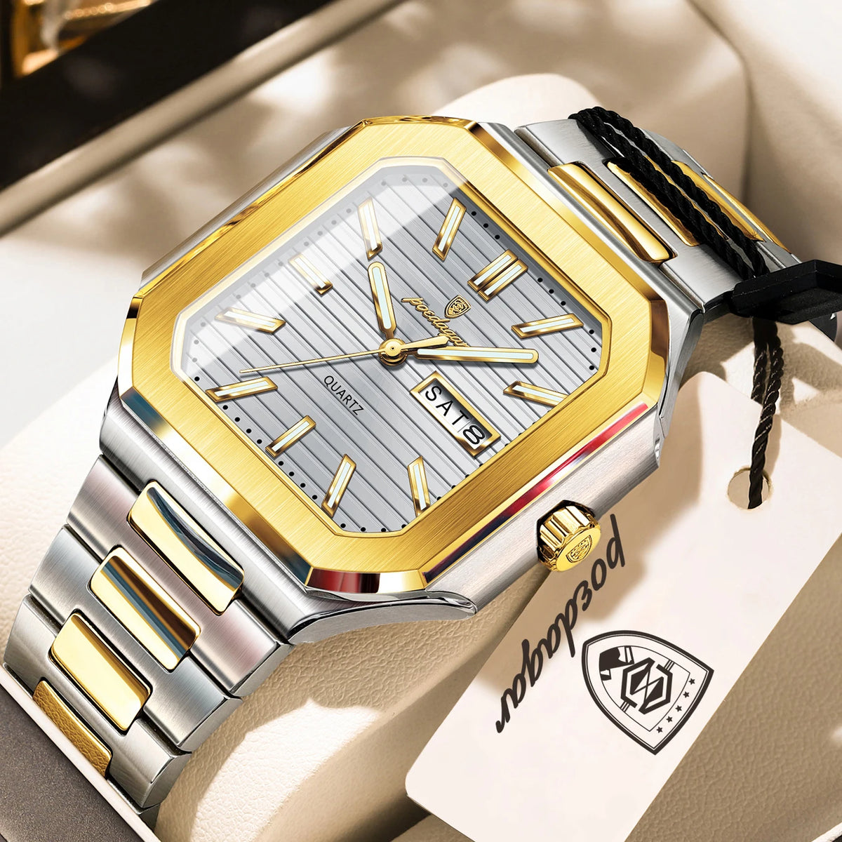 A stainless steel watch with a gold bezel and silver dial is displayed in a box.