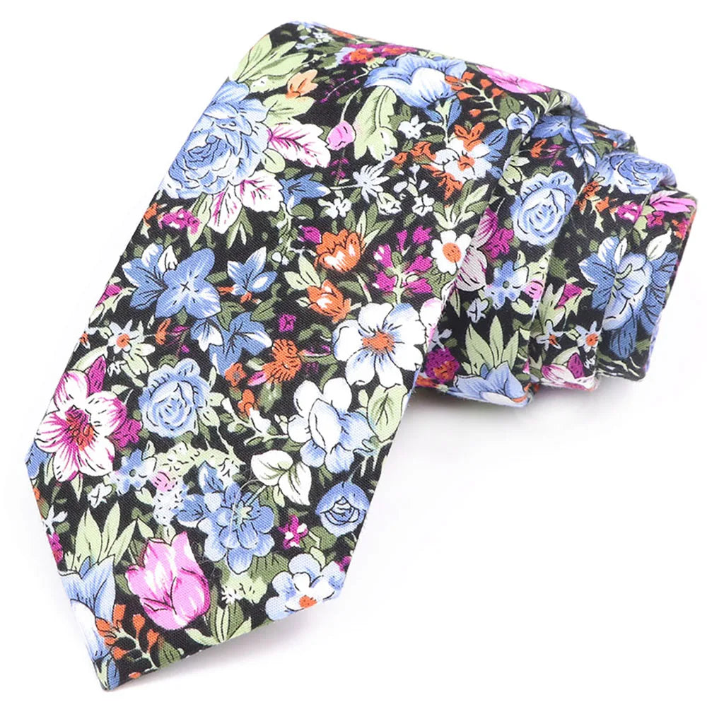 Cravate à motif floral avec des feuilles bleues, roses et vertes sur fond noir.