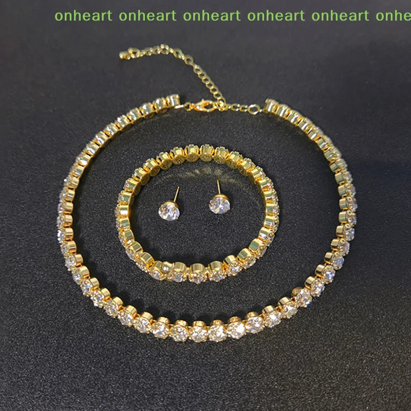A gold-toned necklace and matching earrings set featuring clear crystals.