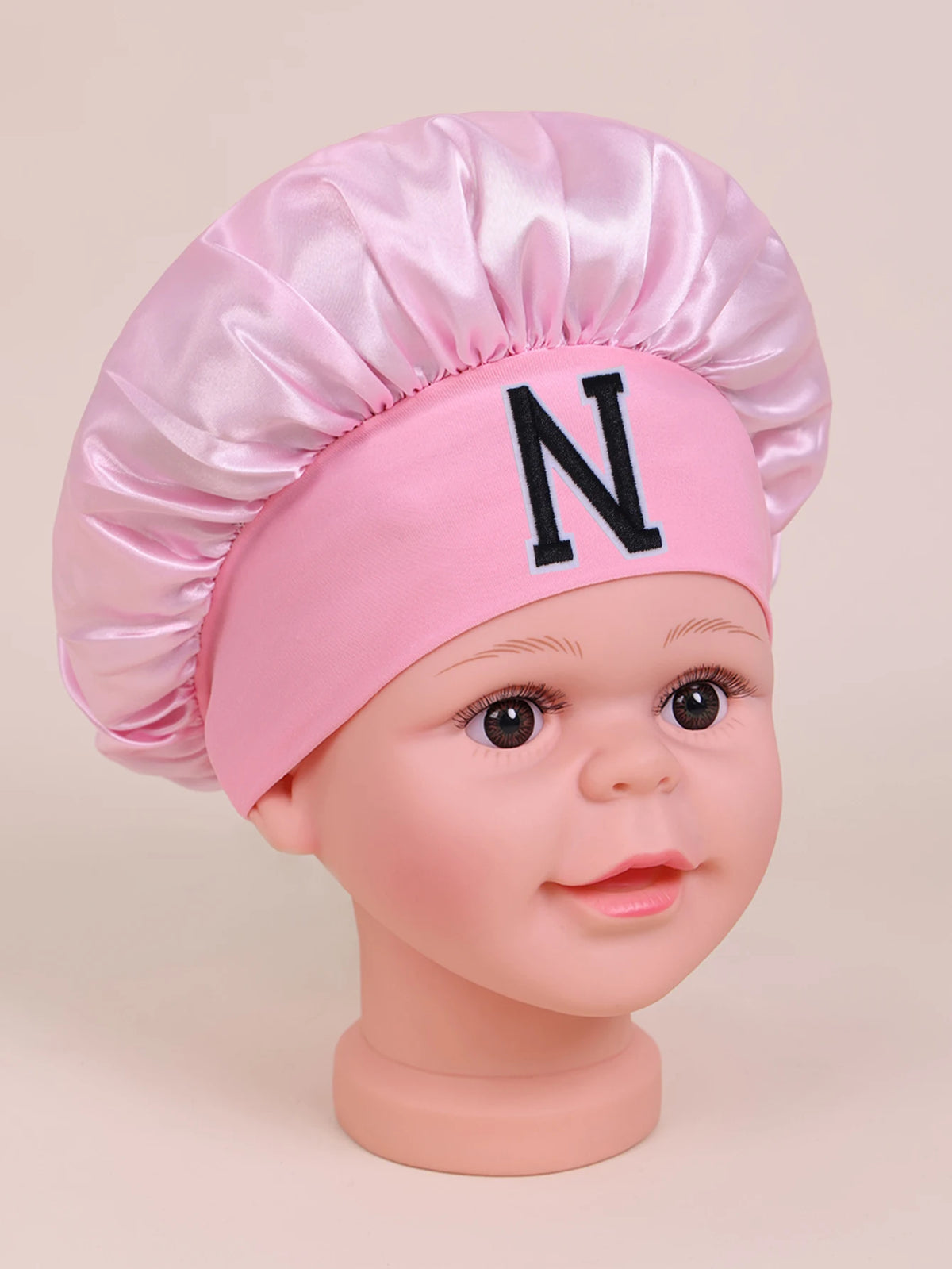 Pink A-Z letter sleep cap for kids with a ruffled toque