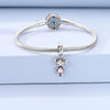 Sterling silver devil's eye charm bracelet with a round blue gemstone and a small pink charm.
