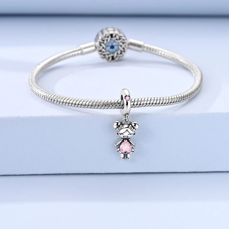Sterling silver devil's eye charm bracelet with a round blue gemstone and a small pink charm.