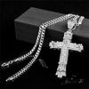 A silver retro Christian cross amulet necklace displayed on a dark surface.