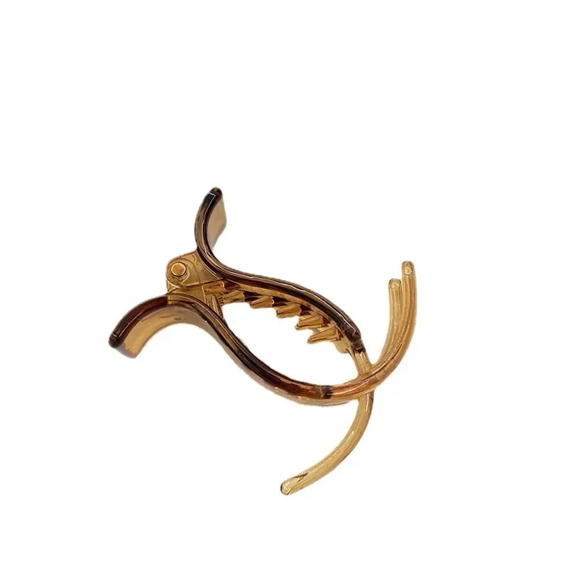 A transparent acrylic hair claw used for styling ponytails.