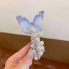 A hand holds a fairy butterfly made of clear glass and white pearls, resembling hair ropes for girls.