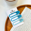 A set of vintage frosted geometry hair clips displayed on a white card next to a piece of paper.