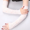 A woman's arms wearing sheer white lace anti-sunburn arm sleeves with red nail polish.