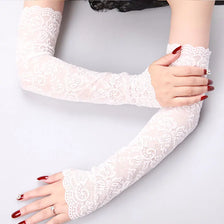 A woman's arms wearing sheer white lace anti-sunburn arm sleeves with red nail polish.