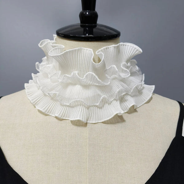 White pleated ruffle stand collar sweater displayed on a black mannequin.
