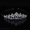 A sparkling crystal hair crown for women, designed in the shape of a royal princess, displayed on a dark reflective surface.