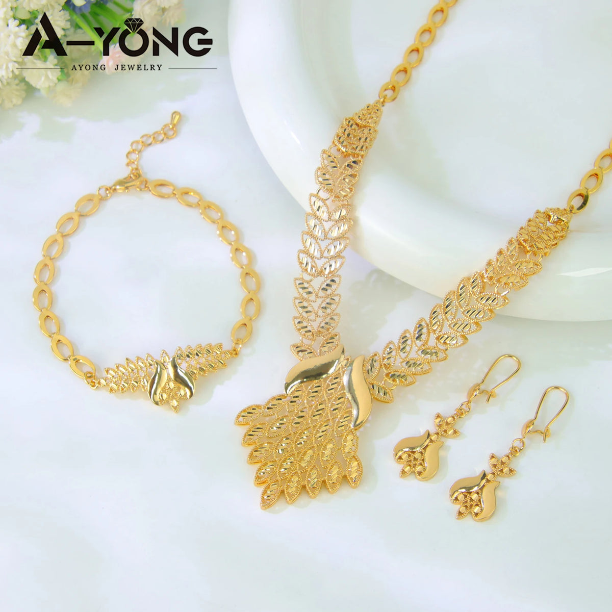 A set of luxury gold plated bridal jewelry including a necklace and earrings displayed on a white background.