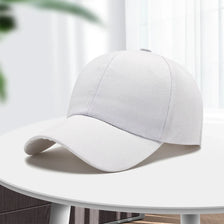 A light gray unisex cotton curved visor hat is displayed on a white table.