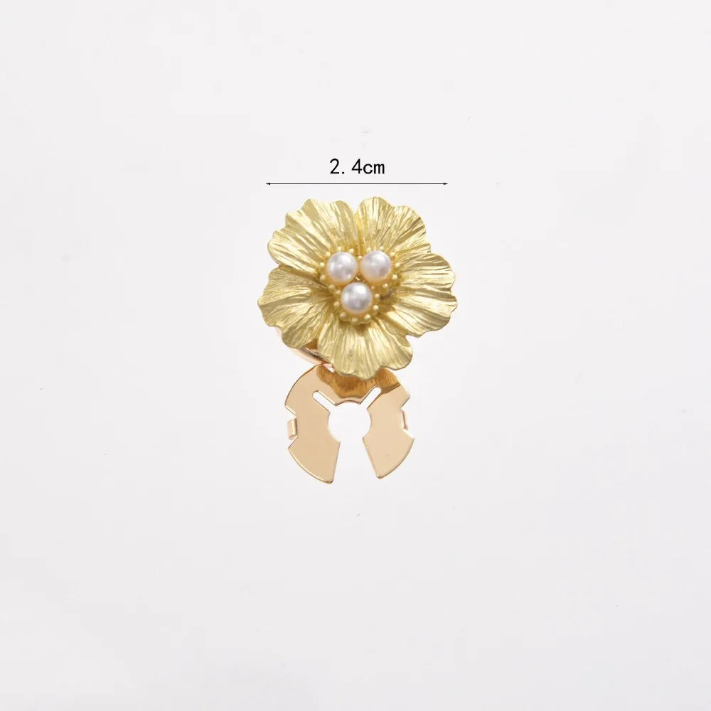 Gold floral button cufflinks with pearl accents and a decorative clasp.