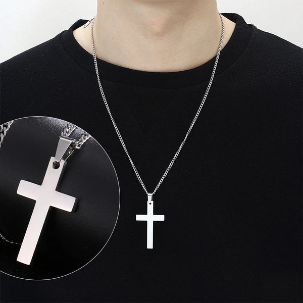 A silver stainless steel cross pendant necklace is displayed against a black shirt with a circular inset showing the pendant 