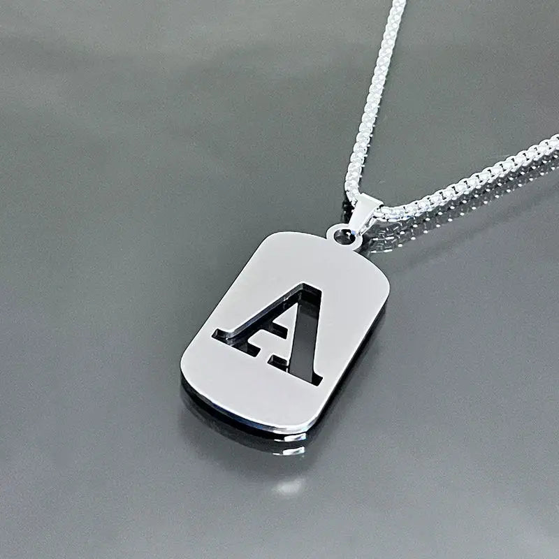 A initial letter stainless steel pendant necklace hanging against a gray background
