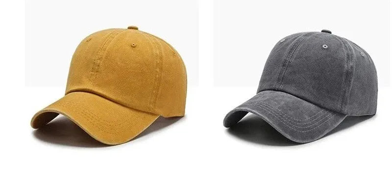A pair of casual baseball caps, one in mustard yellow and one in dark gray.