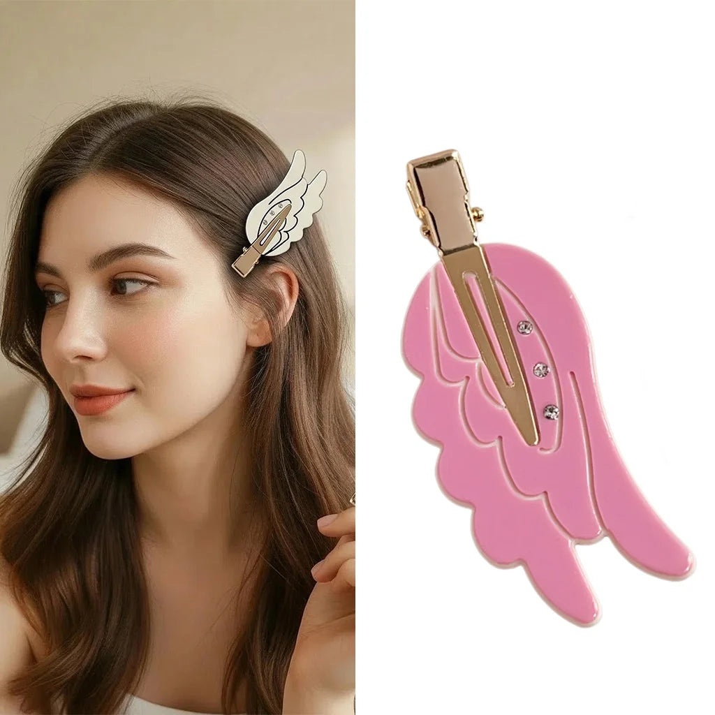 A pink angel wing hair clip and barrette displayed next to a woman's hair.