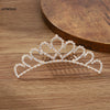 A sparkling crystal princess tiara hair comb for women displayed on a wooden surface.