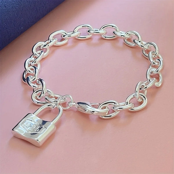 A silver charm lock bracelet made of 925 sterling silver with a chain link design.