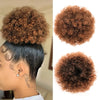 A close-up of a person's hair showing a dark ponytail with reddish-brown kinky drawstring extensions.