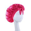 A vibrant pink satin wide-brimmed hair wrap headscarf displayed on a white mannequin.