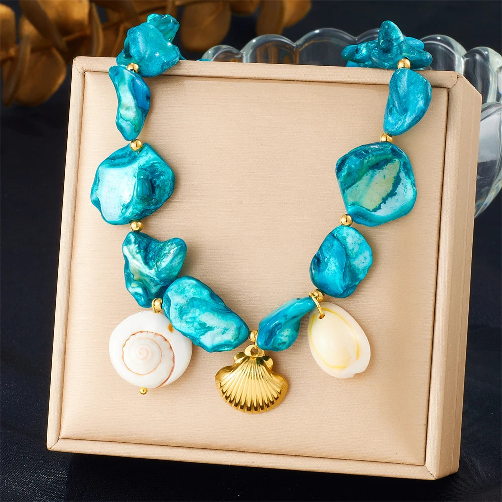 A necklace featuring blue and white sea glass-like pendants shaped like starfish and hearts, presented in a light pink box.