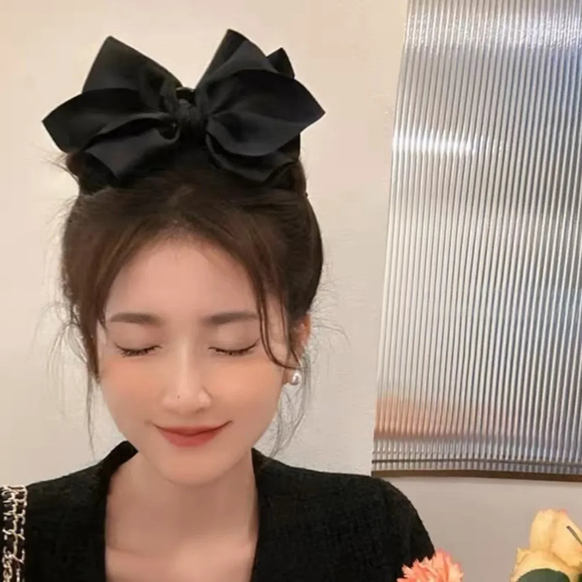 Una mujer usando una pinza para el pelo de lazo negro con un elegante patrón vintage de anacardo en su cabello.