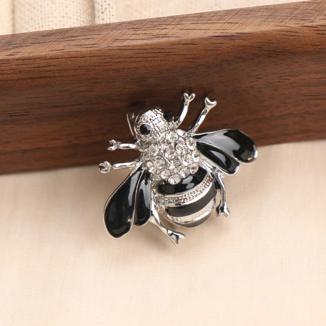 Broche en argent avec un détail d'abeille baroque et d'insecte, émail noir et blanc.