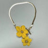 A gold-toned chain necklace with a yellow floral pendant and matching earring.