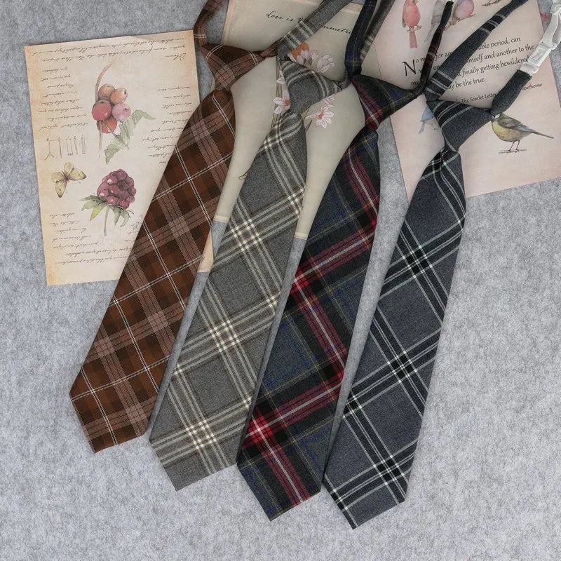 A collection of Japanese plaid neck ties in various patterns laid out on a gray surface.