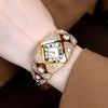 A close-up of a luxury diamond inlaid quartz wristwatch worn on a wrist, featuring a gold casing and diamond-encrusted bezel.