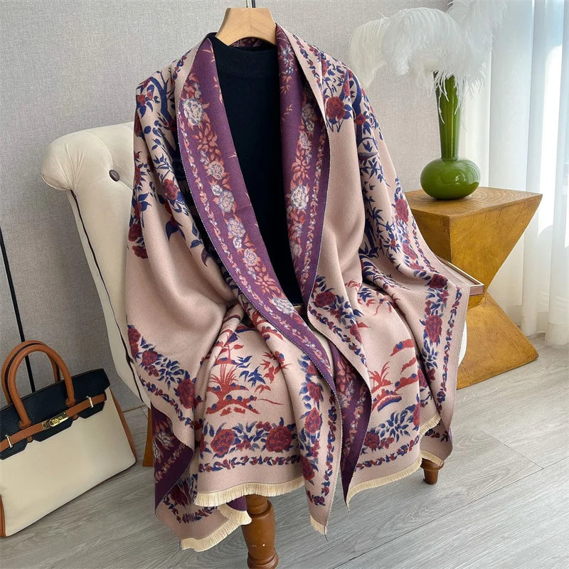 A luxurious plum and pink plaid cashmere scarf draped over a wooden hanger.