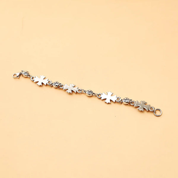 Bracelet en chaîne argentée avec une série de petits charms croix.