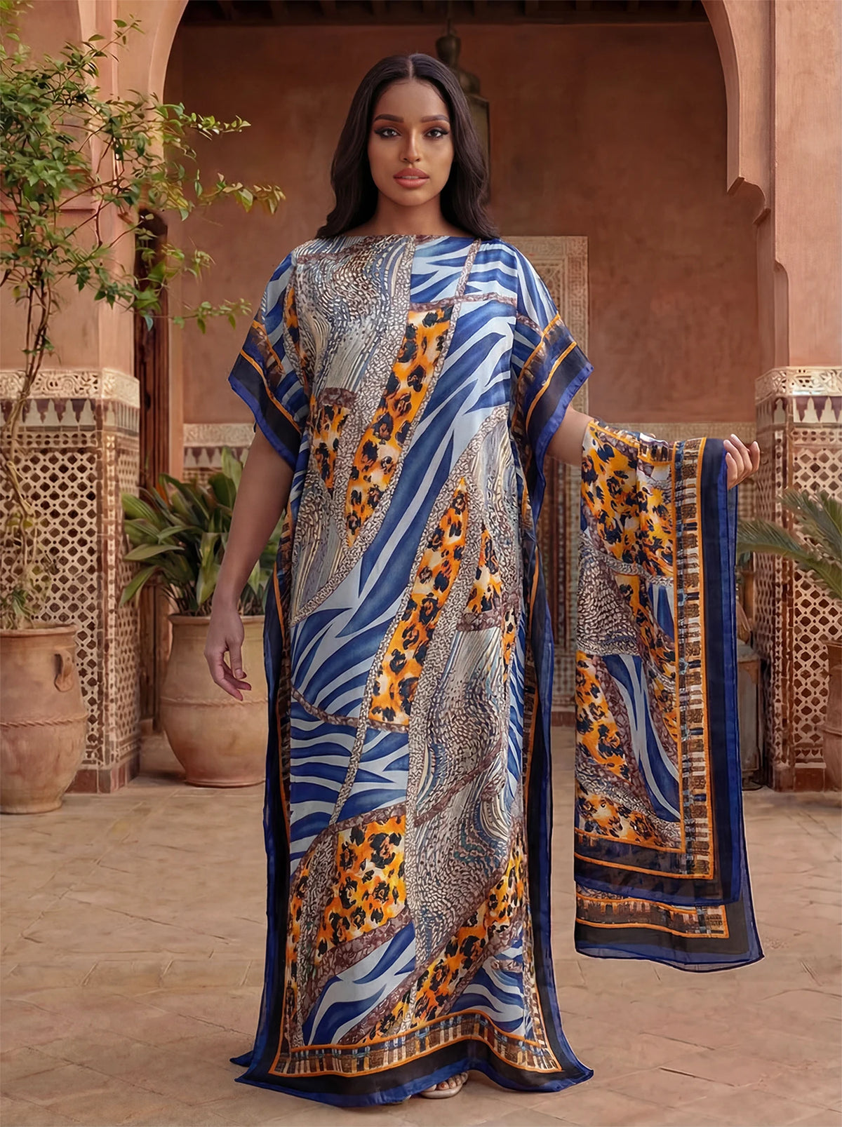 Une femme portant une caftan abaya imprimé léopard zèbre orange et bleu en extérieur.