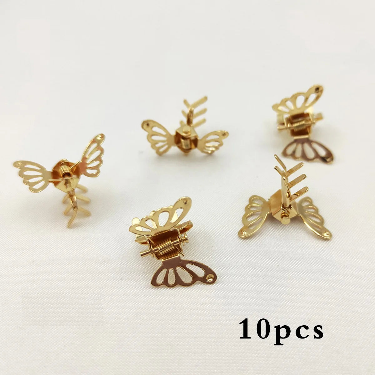 A set of ten mini hollow butterfly metal hair clips in gold and bronze tones.