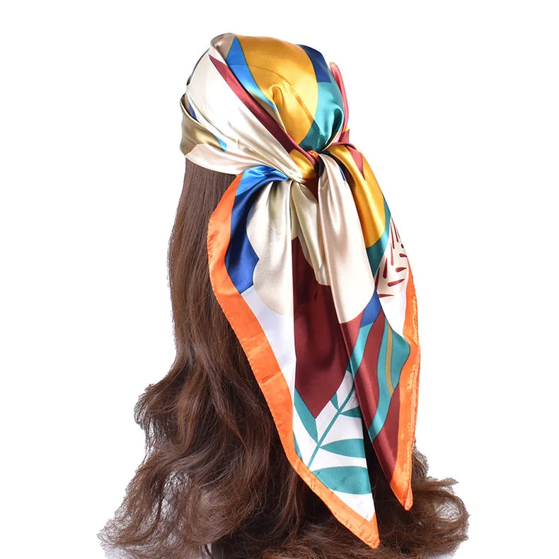 Luxuriöser Seidenschal aus Satin, gebunden, mit leuchtenden Farben wie Gold, Orange, Blau und Grün.