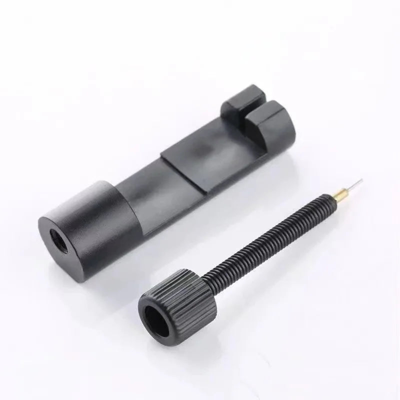 A black adjustable watch band link repair kit showing a metal link and a threaded tool.