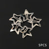 Five silver metal star-shaped hair clips arranged in a circle against a dark background