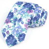 Une pile de nœuds à col en coton à imprimé floral élégants dans des tons de bleu et de violet.