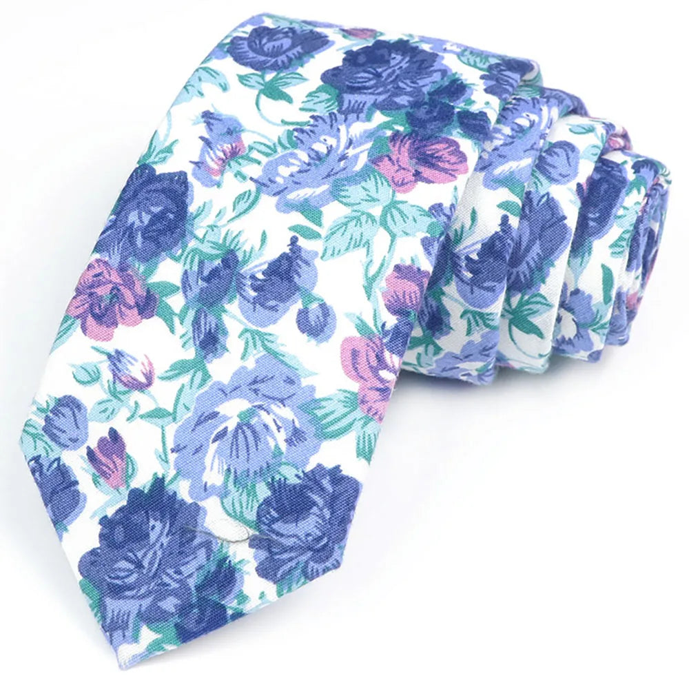 Une pile de nœuds à col en coton à imprimé floral élégants dans des tons de bleu et de violet.