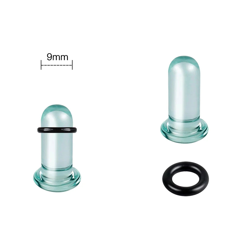 A clear glass ear stretching plug with a black ring and a measuring scale showing 9mm.
