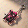 A clear acrylic keychain featuring a black and pink stylized character design on a silver keyring.
