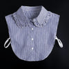 A striped blue and white blouse with a ruffled false collar and tie-back details.