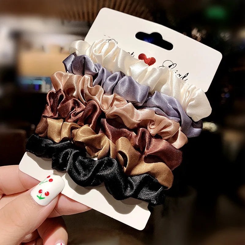 A collection of elegant simulation silk hair ties in various shades of beige, gray, and brown is displayed on a white card.