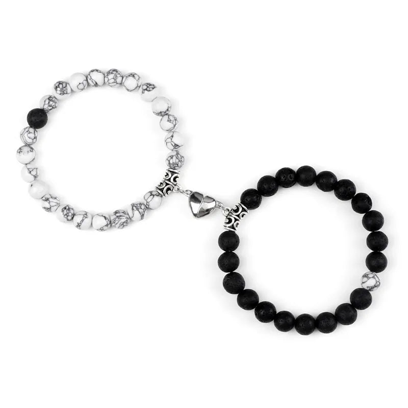 A pair of natural stone heart couple bracelets, one white and one black, displayed against a white background.