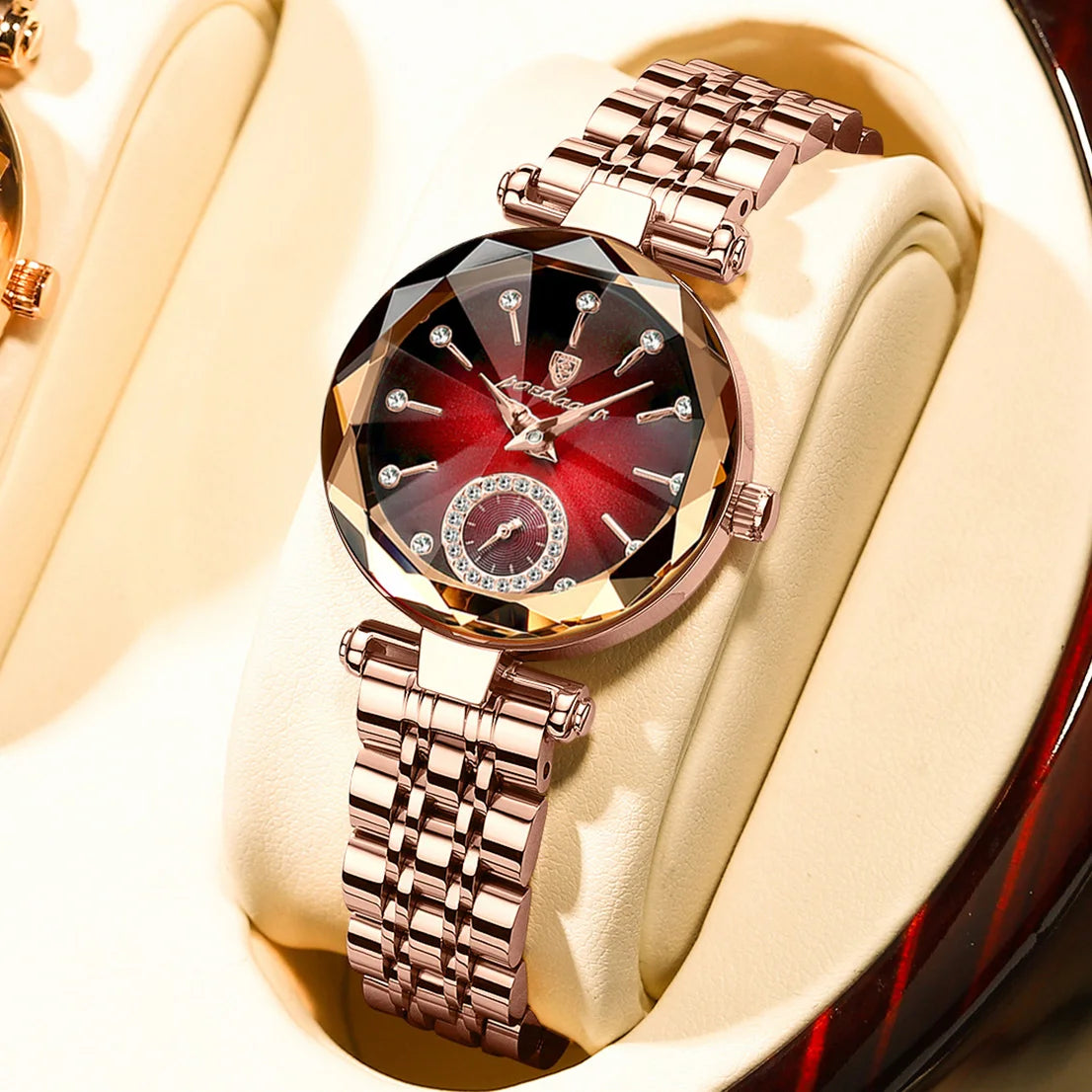 A close-up of an elegant stainless steel quartz ladies wristwatch with a red and gold dial and matching bracelet, displayed o