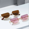 Gafas de estilo ojo de gato retro con marco dorado en tonos marrón y rosa, mostradas sobre una superficie blanca.