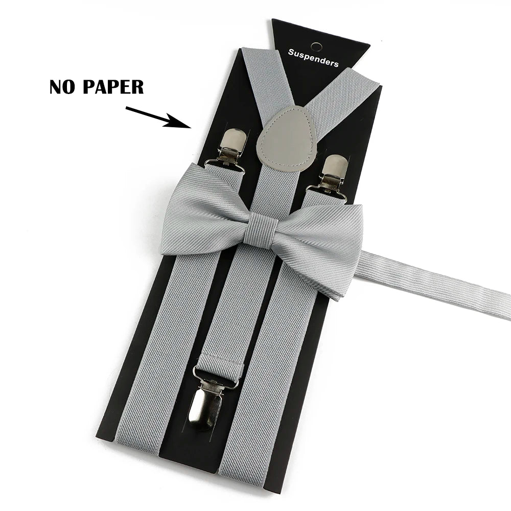 A set of gray adjustable polyester suspenders and bow ties displayed on a black card.