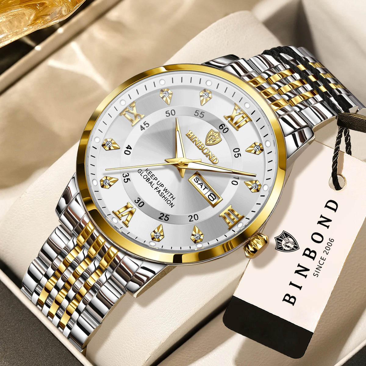 A silver and gold BINBOND luminous quartz wristwatch with a metal bracelet resting on a light-colored surface.